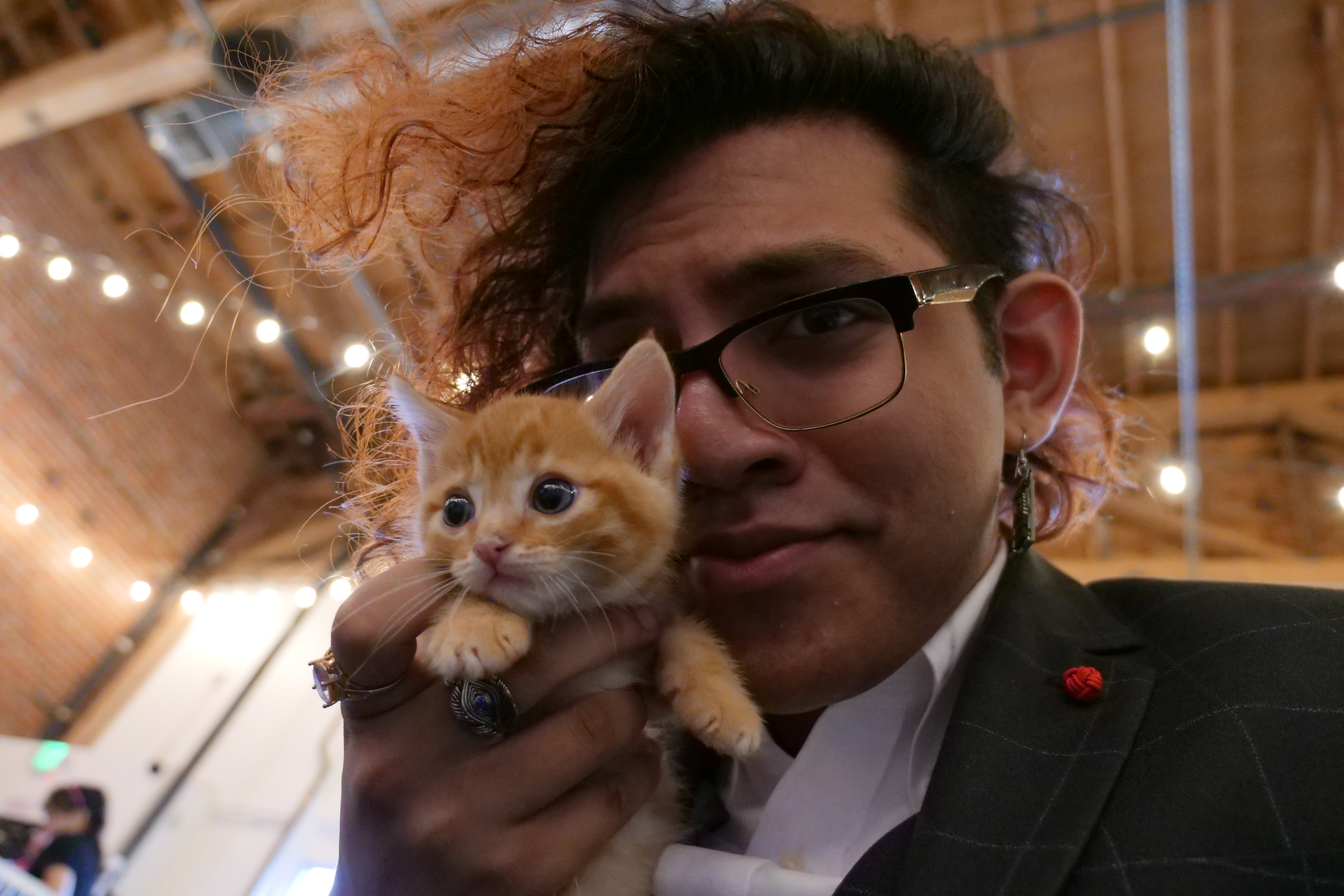 Alif Jakir holding a small orange tabby kitten